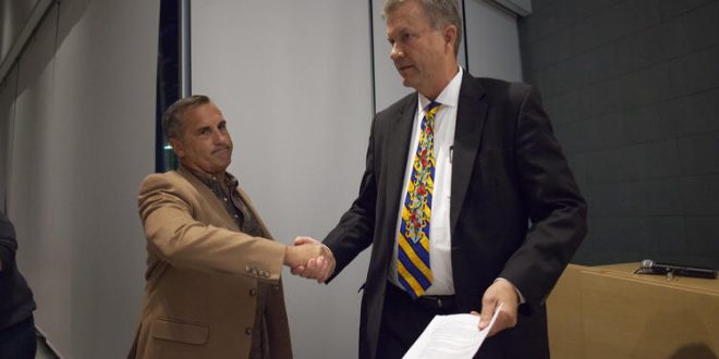 Newport Beach Harbor Commission Chairman Paul Blank, left, shakes hands with Councilman Scott Peotter as Blank serves him with an intent to recall notice during Tuesday night's City Council meeting. (Kevin Chang | Daily Pilot)